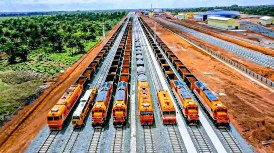 Locomotives et rames de wagons minéraliers alignées sur les voies d'une gare de triage en Guinée
